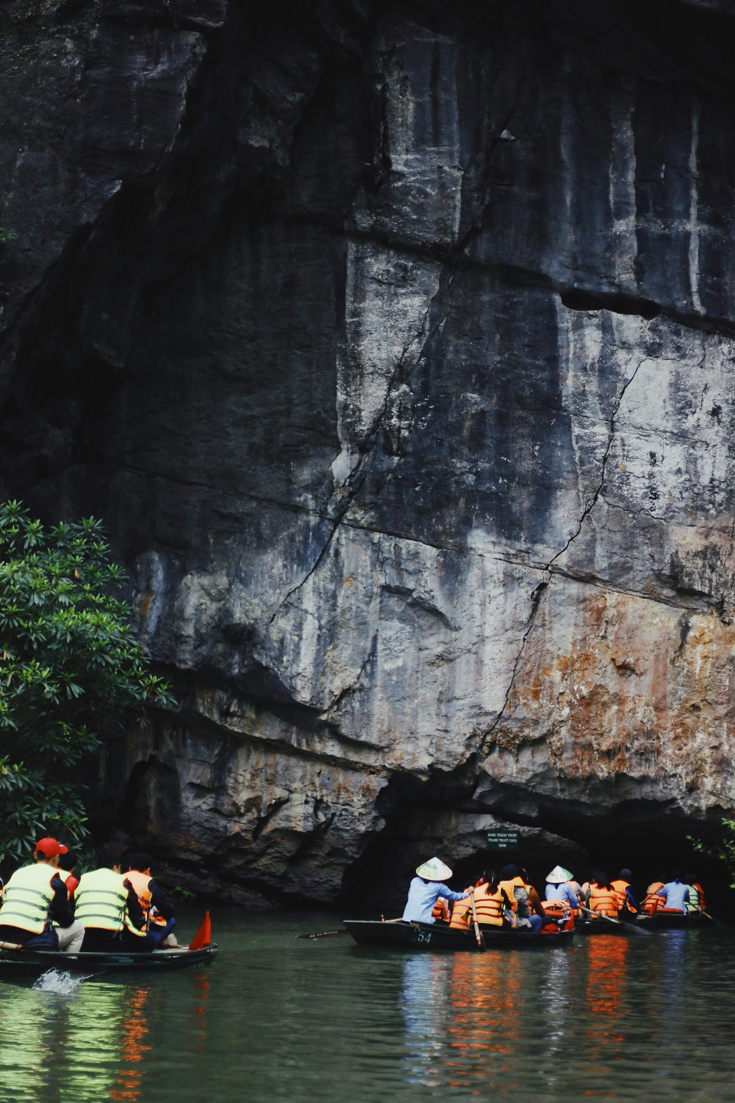 people on boat near rock